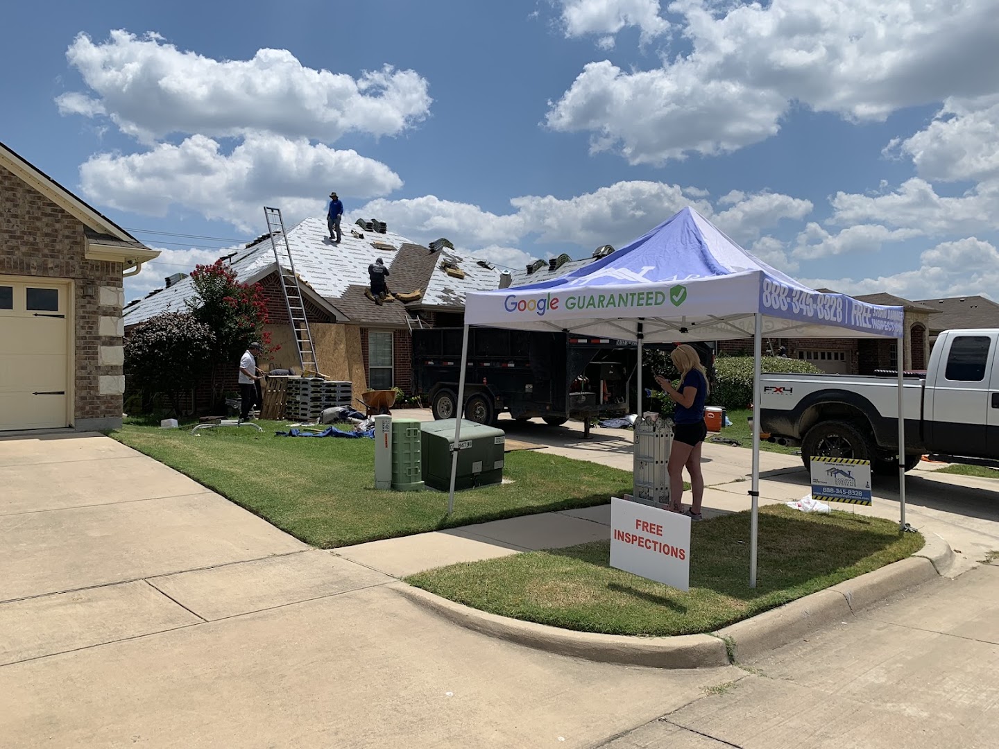 Roofing job site with company tent and truck